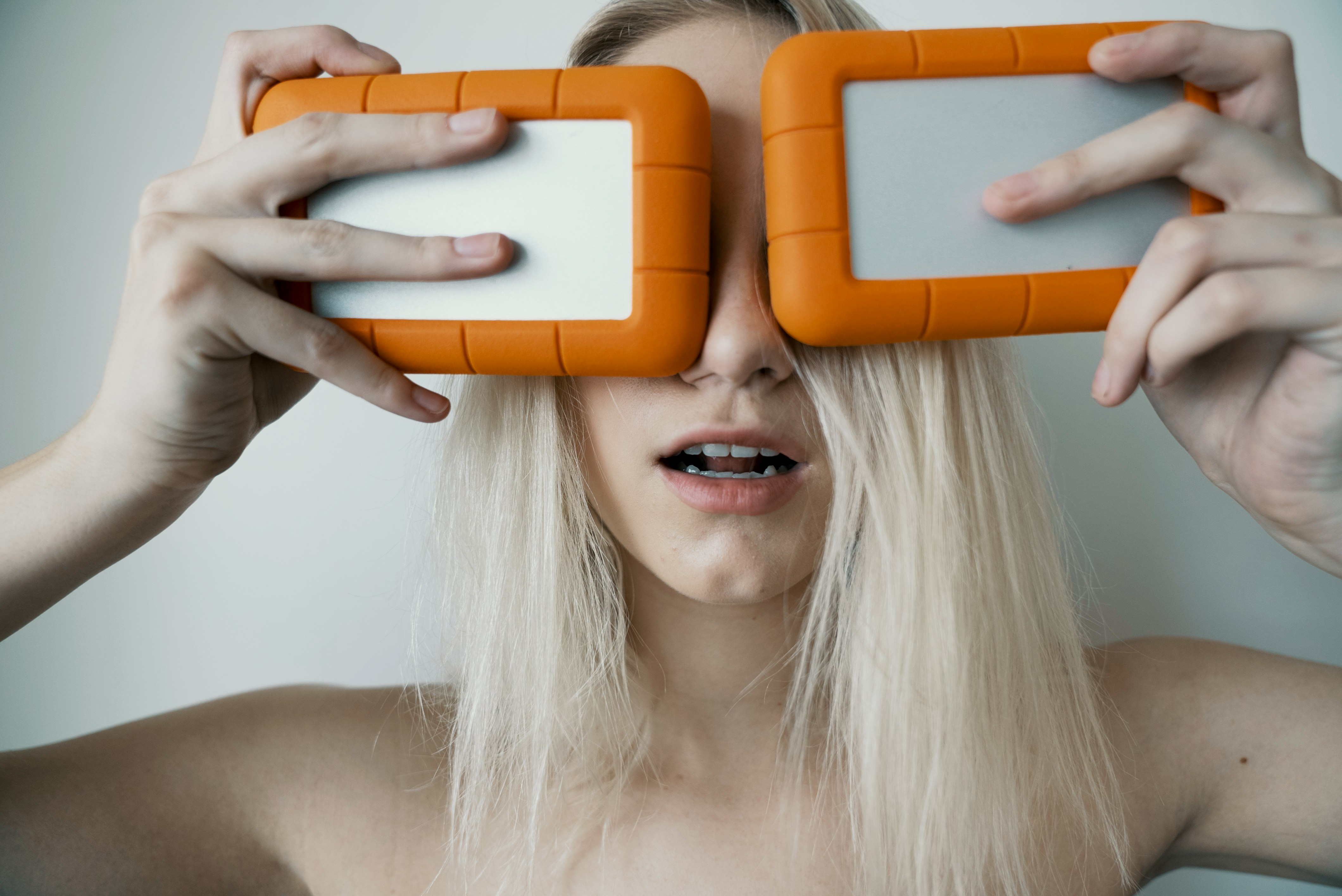 woman holding two white-and-orange plastic cases